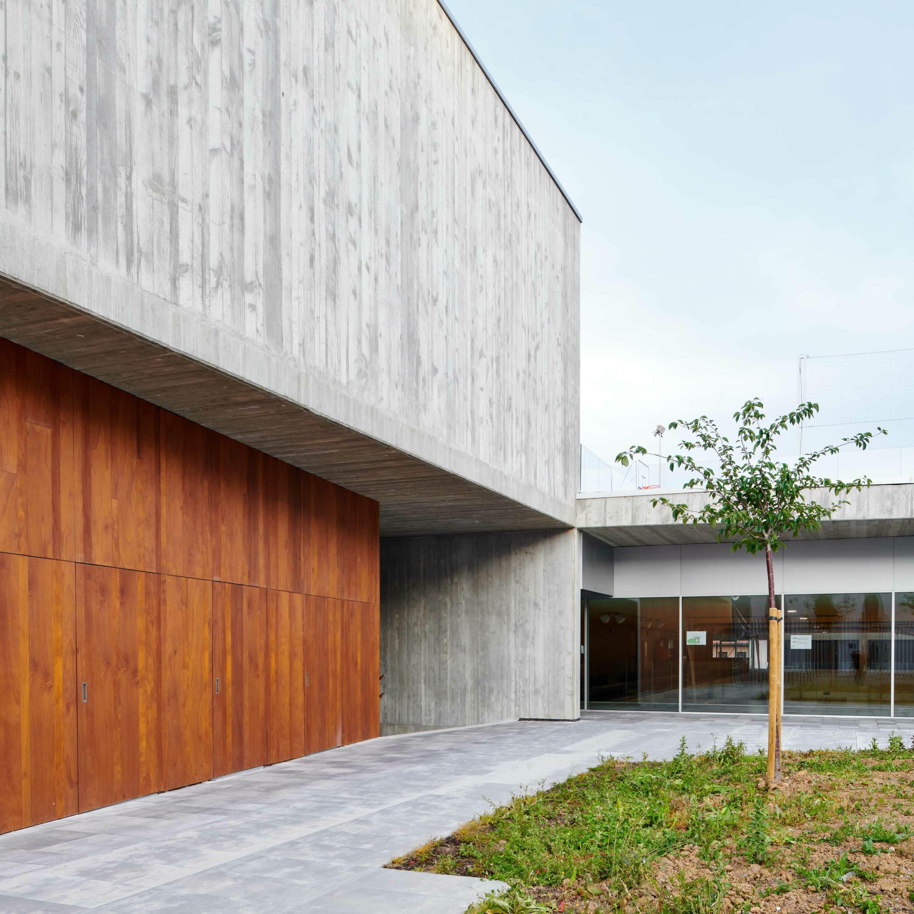 L'installation verticale des lames accentue le rythme visuel entre le béton et le bois.