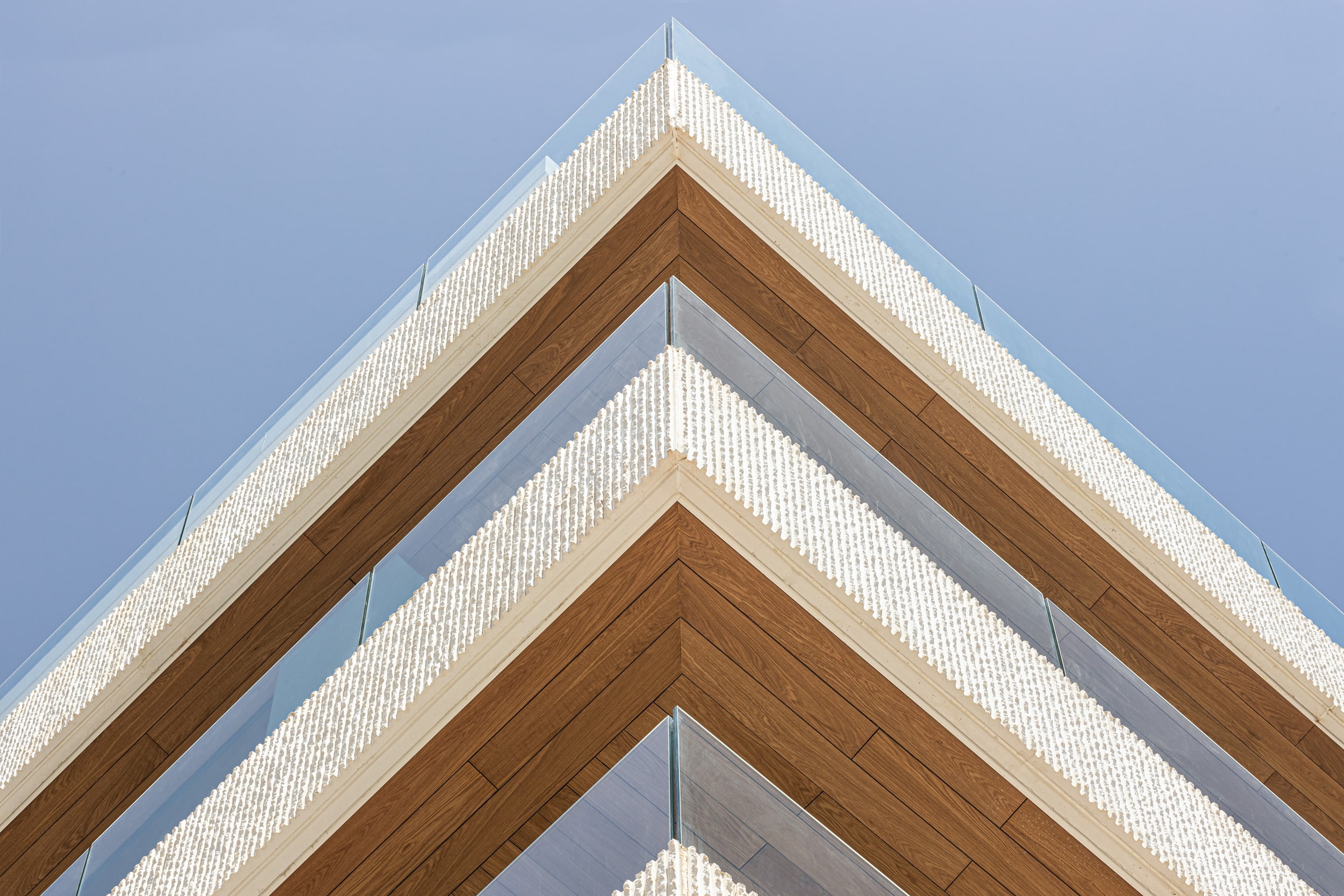 El edificio de apartamentos frente al mar Mediterráneo 176, en Málaga, utiliza techo falso exterior de madera natural Parklex Prodema en los balcones.